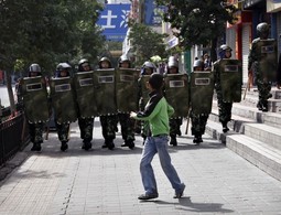 REPRESIJA U XINJIANGU Kineski policajci i ujgurski
dječak u Urumqiju; u
prošlogodišnjim neredima 2009. bilo je na stotine poginulih i više tisuća ranjenih