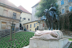KIP SVOG ZAŠTITNIKA svetog Jurja, čije postolje prikazuje ubijenog zmaja, Družba je postavila na zagrebački trg koji nosi njezino ime. Trg se nalazi ispred Kamenitih vrata gdje je sjedište Družbe