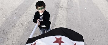 Dječak maše sirijskom zastavom za vrijeme
demonstracija protiv Assada i njegovih pristalica