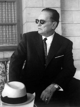U CRNOM KLASIČNOM
odijelu, s bijelim šeširom, crnim sunčanim naočalama
i satom; tipična
Titova fotografija koja
pokazuje kako su fotografi pomno režirali
predsjednikov imidž