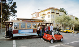 PUTNICI ČUVENOG tramvaja u San Franciscu začuđeno promatraju minijaturno vozilo koje će se u SAD-u početi prodavati u siječnju 2008.