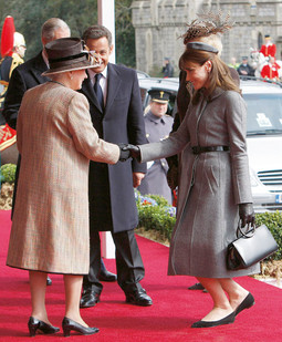 U LONDON je Carla Bruni stigla u mekom sivom vunenom kaputu s tankim remenom, crnim rukavicama i balerinkam