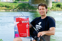 FILMSKI VUKOVARAC Igor Rakonić, osnivač Vukovar film festivala, s plakatom festivala i ribičkim štapom na obali Dunava