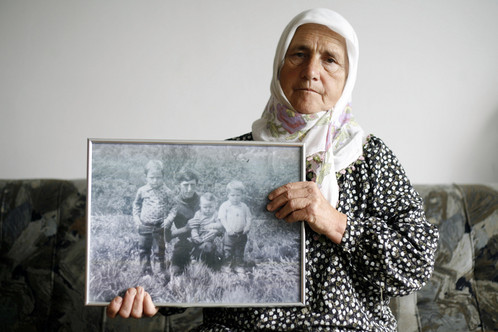 Munira Salihović pokazuje fotografiju na kojoj se nalaze suprug i tri sina Redžep, Sabahudin, Fahrudin i Resid. Svi su pobijeni u srebreničkom masakru (Reuters)